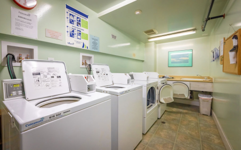 Harvard Apartments common area laundry room featuring two washer and two dryer machines